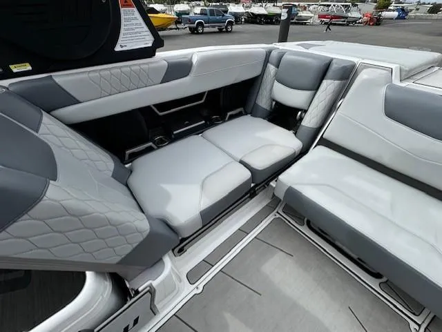 Slide: The Image of 2021 Malibu M240 boat interior with gray and white seating, featuring quilted upholstery. - 18