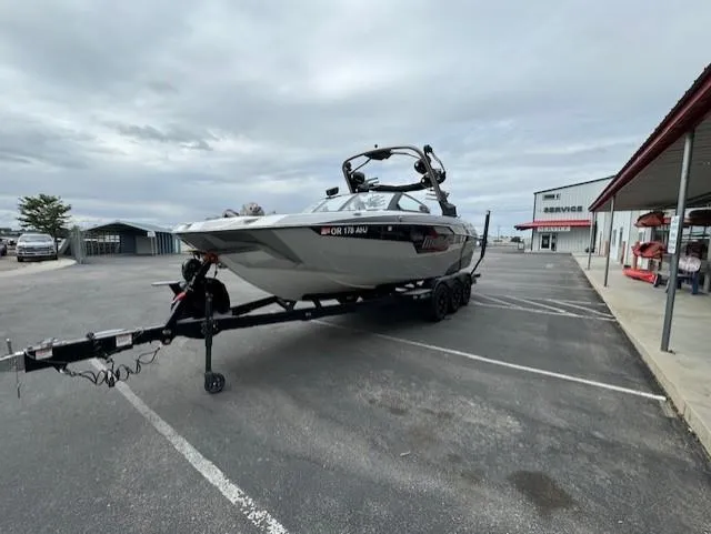 Slide: The Image of 2021 Malibu M240 boat on trailer in parking lot, overcast sky. - 7