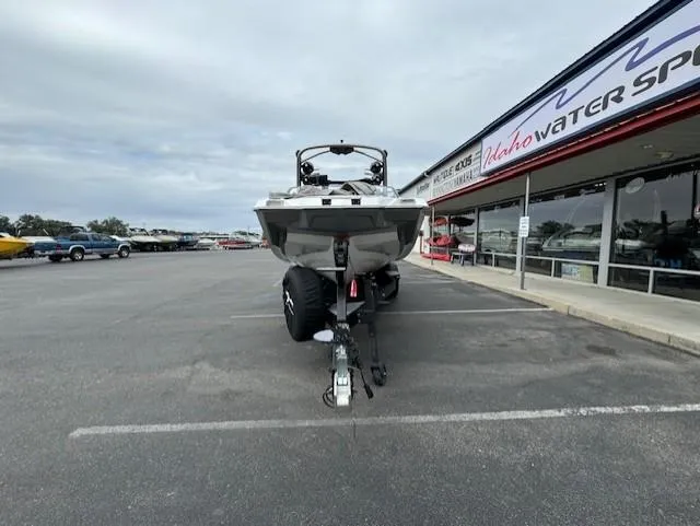 Slide: The Image of 2021 Malibu M240 boat on trailer in parking lot near water sports store. - 8