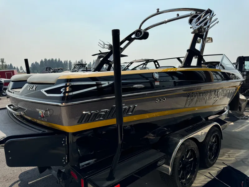 Slide: The Image of 2013 Malibu WVLX boat with sleek black and yellow design, parked on a trailer. - 3