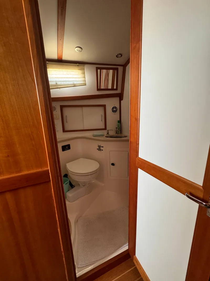 Slide: The Image of 2005 Sabre 38 yacht bathroom with wooden accents and compact design. - 13