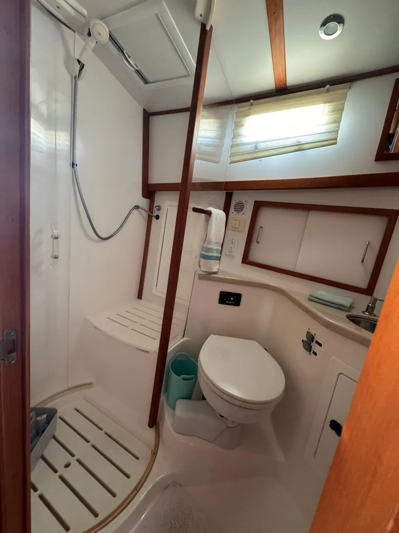 Slide: The Image of 2005 Sabre 38 yacht bathroom with shower, toilet, and storage cabinets. - 14