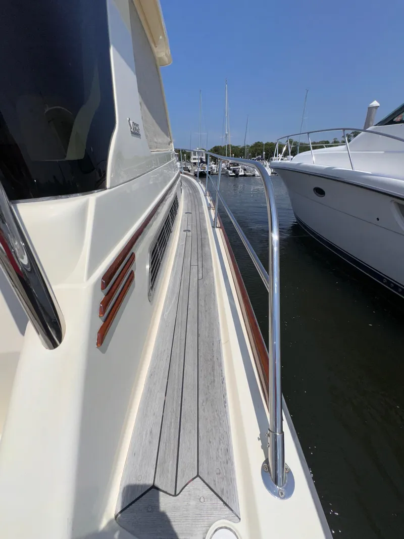 Slide: The Image of 2005 Sabre 38 yacht deck view, docked in marina under clear blue sky. - 30