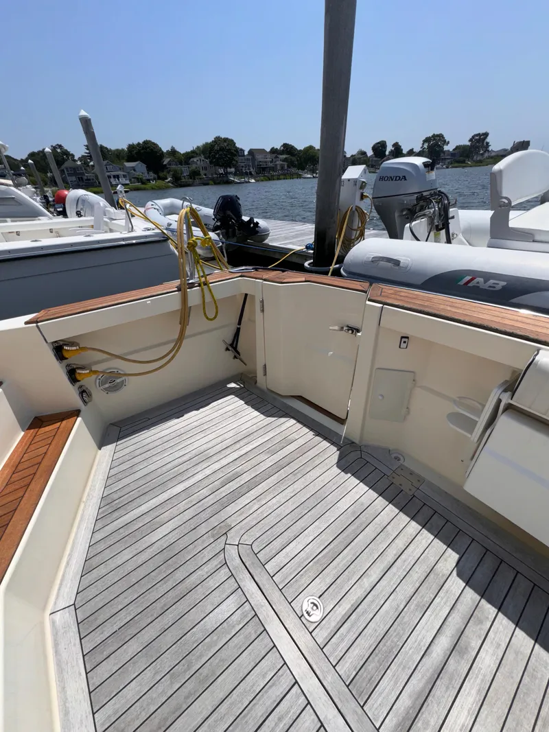 Slide: The Image of 2005 Sabre 38 boat deck with wood flooring and docked view. - 36