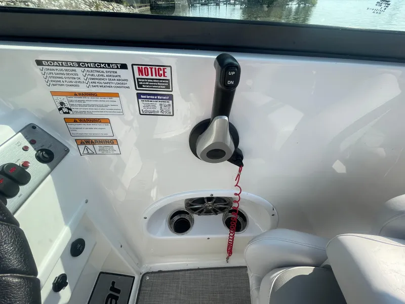 Slide: The Image of 2021 NauticStar 223 DC Deck boat interior with control panel and safety notices. - 10