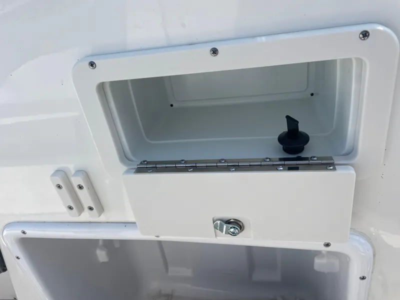 Slide: The Image of 2021 NauticStar 223 DC Deck boat storage compartments with latch and hinge. - 11