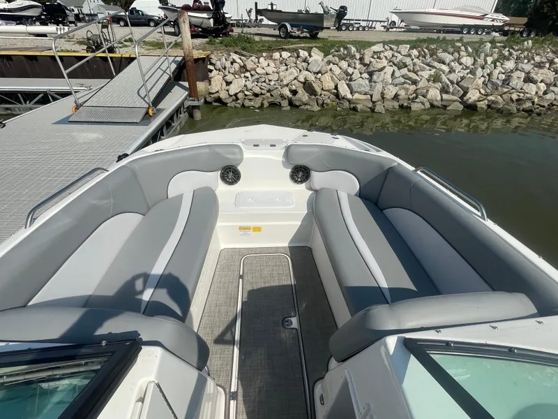 Slide: The Image of 2021 NauticStar 223 DC Deck boat interior with gray seating at dock. - 13