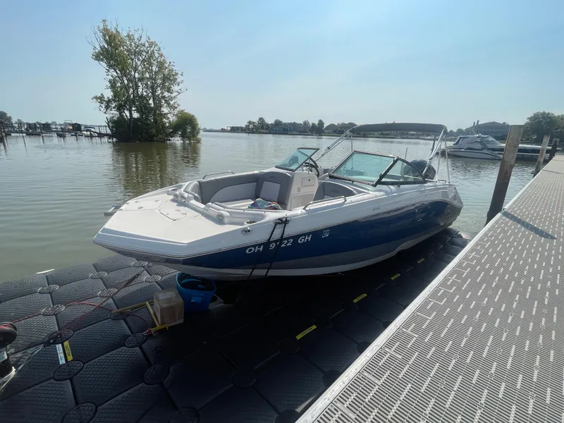 Slide: The Image of 2021 NauticStar 223 DC Deck boat docked on a sunny day. - 18