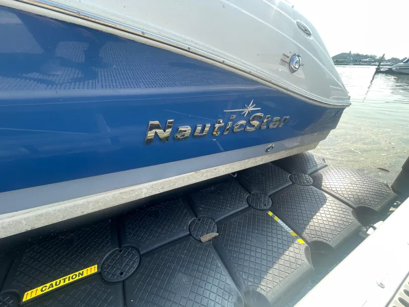 Slide: The Image of 2021 NauticStar 223 DC Deck boat docked on floating platform. - 21
