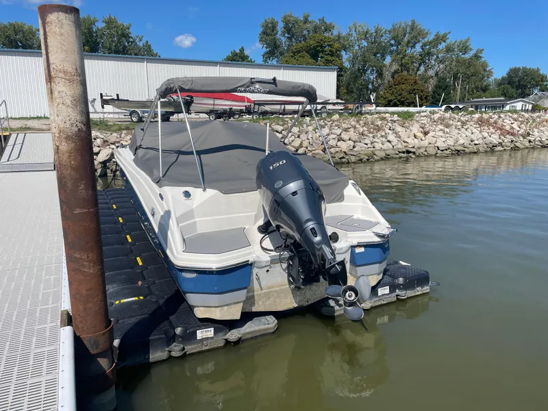 Slide: The Image of 2021 NauticStar 223 DC Deck boat docked on calm water. - 3