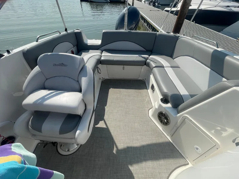 Slide: The Image of 2021 NauticStar 223 DC Deck boat interior with gray seating and waterfront view. - 5