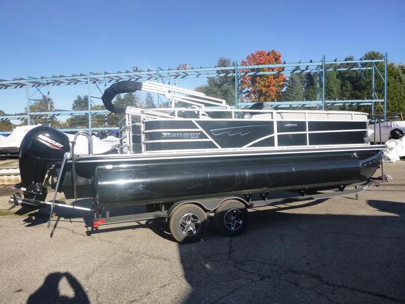 The Image of 2024 Ranger Reata 223C pontoon boat on trailer, outdoors, sunny day. - 0