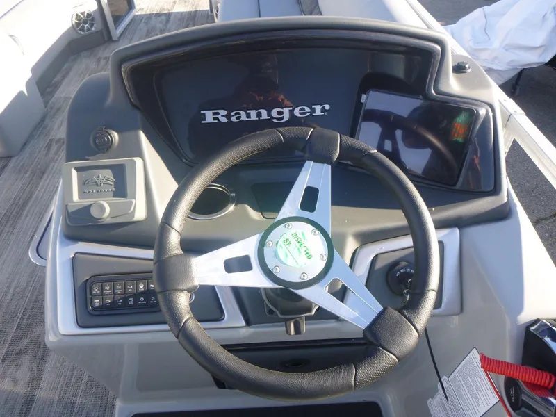 Slide: The Image of 2024 Ranger Reata 223C boat dashboard with steering wheel and controls. - 10