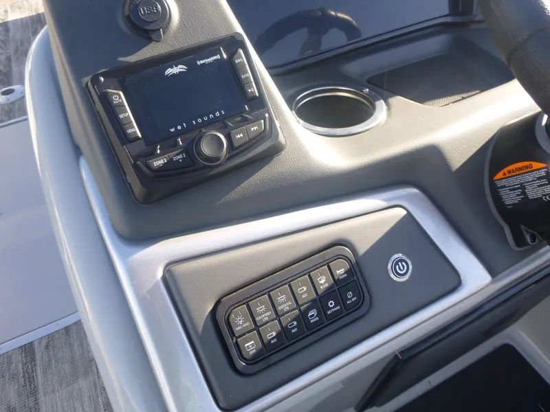 Slide: The Image of 2024 Ranger Reata 223C boat dashboard with control panel and cup holder. - 11