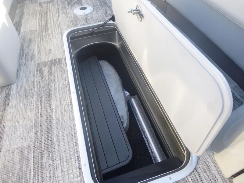 Slide: The Image of 2024 Ranger Reata 223C boat storage compartment with open lid, showcasing interior space. - 15
