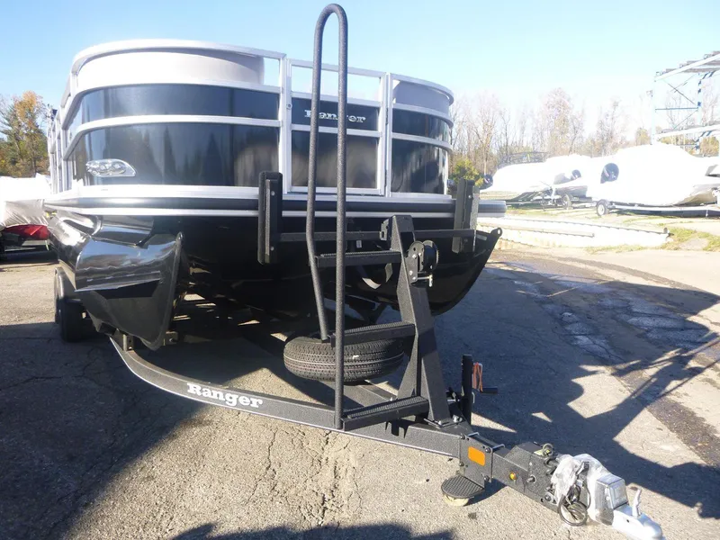 Slide: The Image of 2024 Ranger Reata 223C pontoon boat on trailer in outdoor setting. - 2