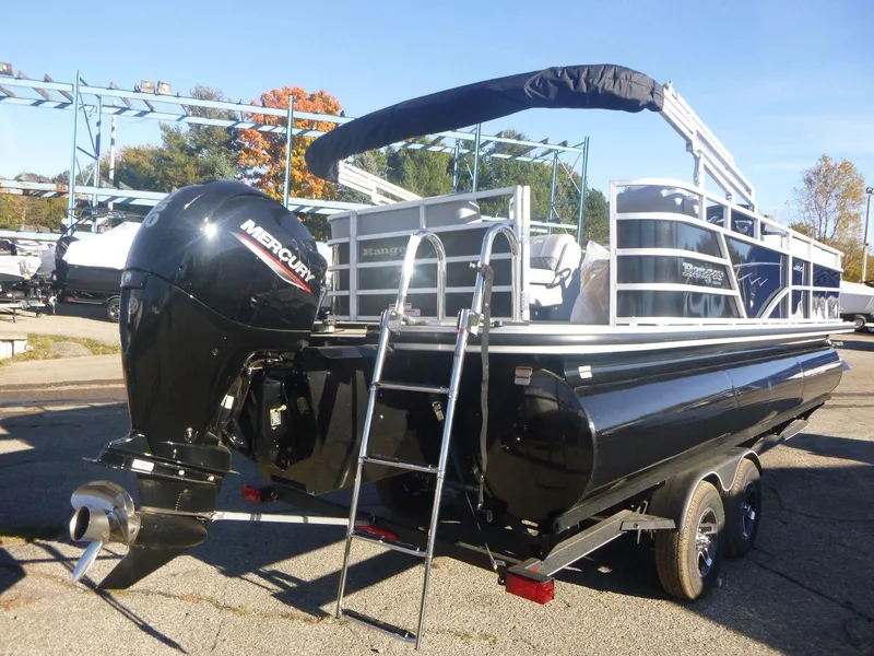 Slide: The Image of 2024 Ranger Reata 223C pontoon boat with Mercury outboard engine, parked on a trailer. - 4