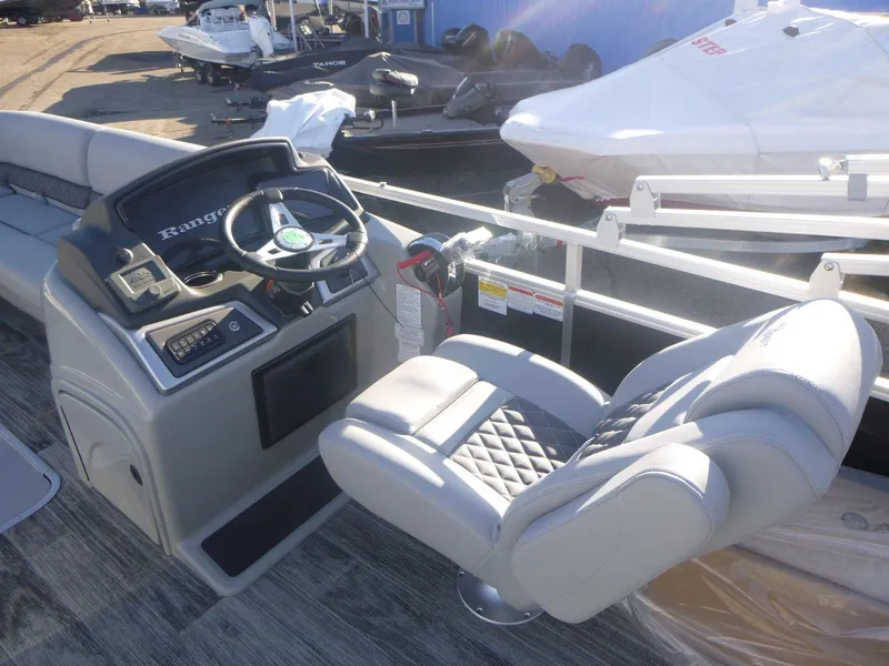Slide: The Image of 2024 Ranger Reata 223C boat interior with steering wheel and cushioned seating. - 9