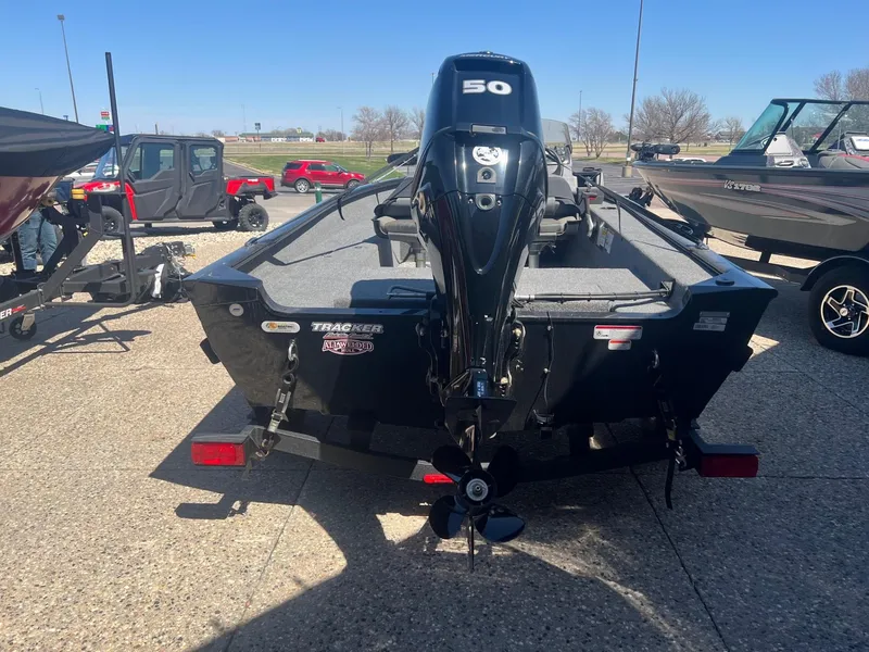 Slide: The Image of 2025 Tracker Super Guide V-16 SC boat with 50 HP motor, parked outdoors. - 2