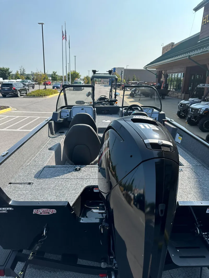 Slide: The Image of 2025 Tracker Pro Guide V-175 WT boat with sleek design in parking lot. - 3