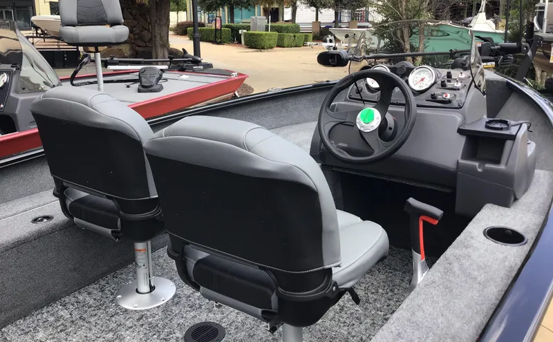 Slide: The Image of 2025 Tracker Super Guide V-16 SC boat interior with steering wheel and seating. - 2