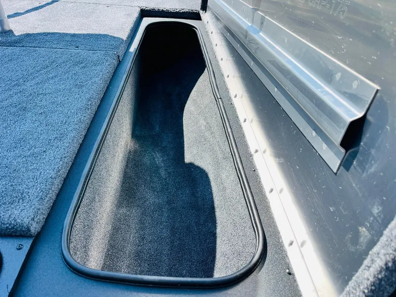 Slide: The Image of 2025 Tracker Pro Team 175 boat storage compartment with carpeted interior. - 17