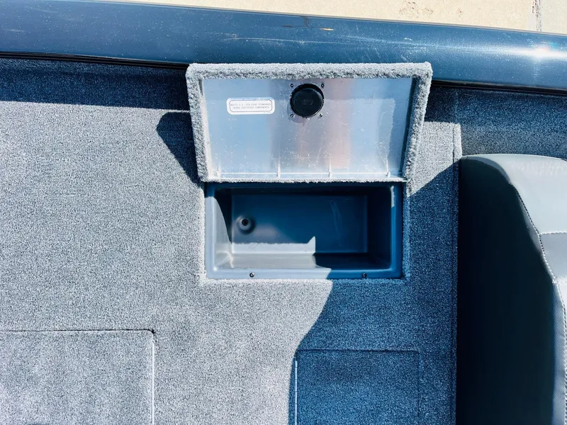 Slide: The Image of 2025 Tracker Pro Team 175 boat storage compartment with carpeted interior. - 36