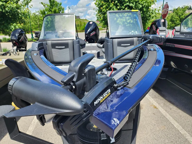 Slide: The Image of 2025 Tracker Targa V-18 Combo boat with Minn Kota trolling motor, parked outdoors. - 2