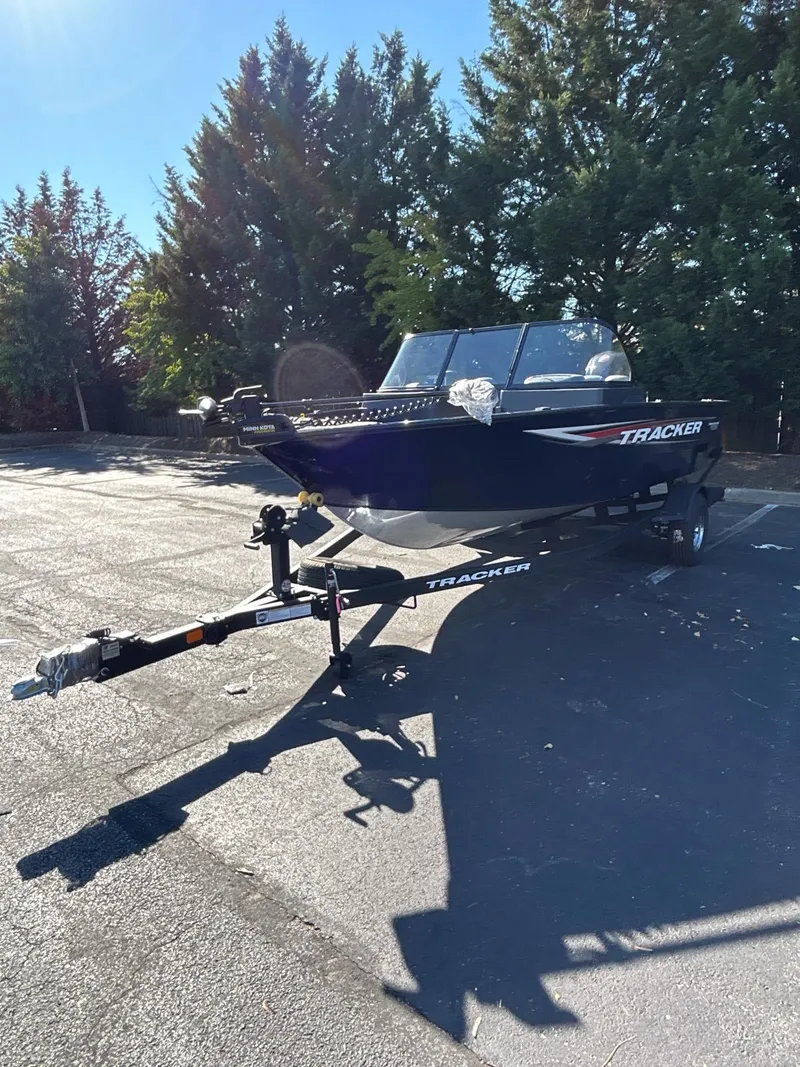 Slide: The Image of 2025 Tracker Pro Guide V-175 WT boat on trailer in sunny outdoor setting. - 2