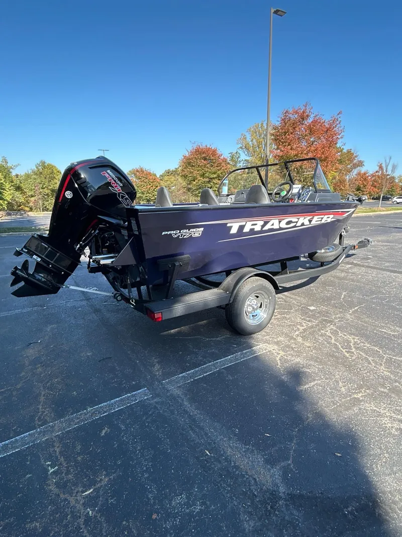Slide: The Image of 2025 Tracker Pro Guide V-175 WT boat on trailer, parked outdoors, with autumn trees in background. - 3