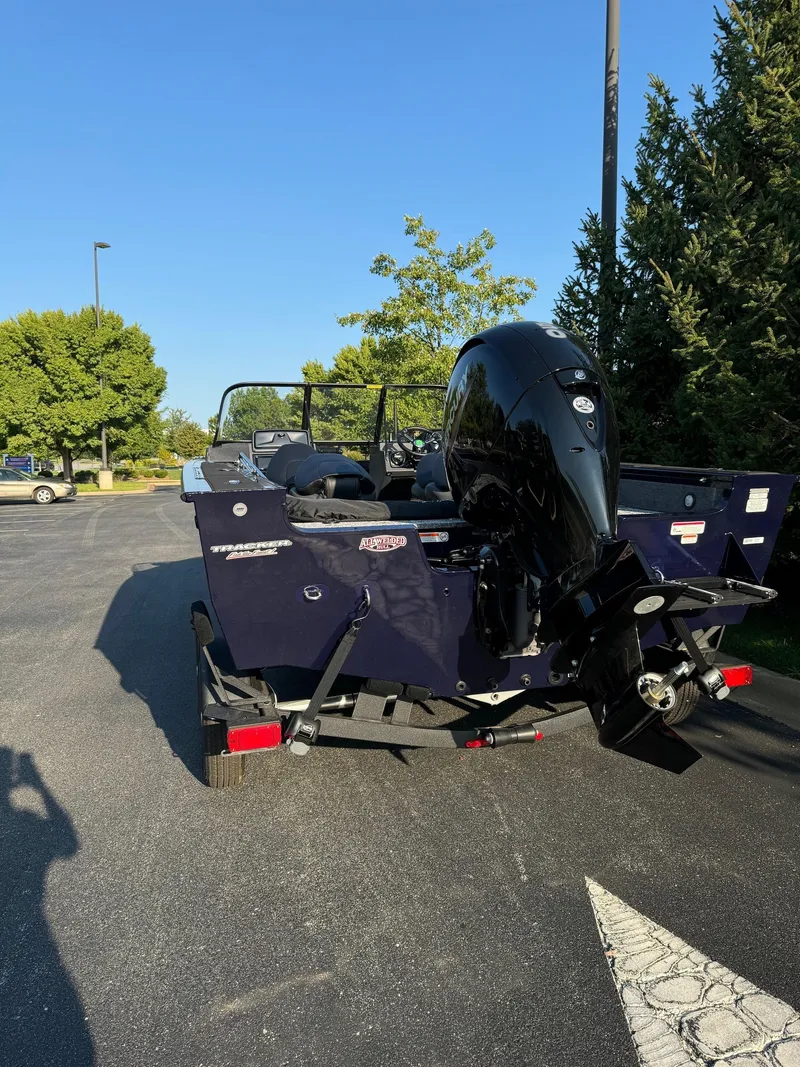 Slide: The Image of 2025 Tracker Targa V-18 Combo boat with outboard motor in parking lot. - 5