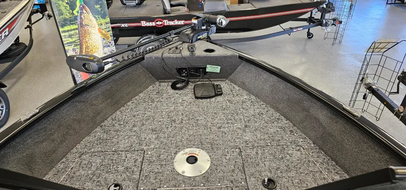 Slide: The Image of 2025 Tracker Pro Guide V-175 WT boat interior with carpeted deck in showroom. - 2