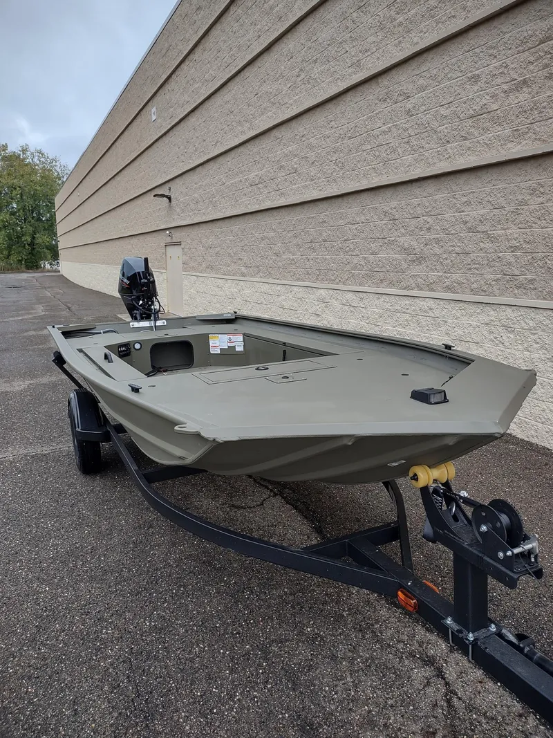 Slide: The Image of 2025 Tracker Grizzly 1654 T Sportsman boat on trailer, parked outdoors. - 3