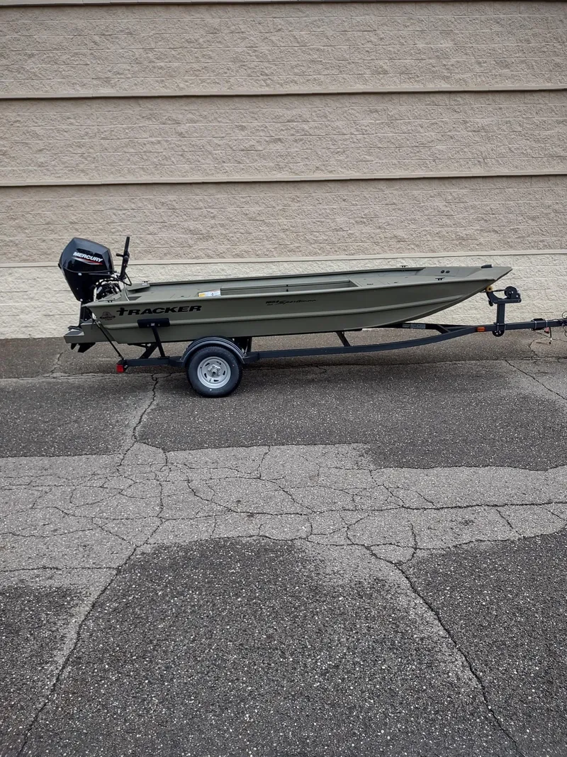 Slide: The Image of 2025 Tracker Grizzly 1654 T Sportsman boat on trailer, parked on asphalt. - 4