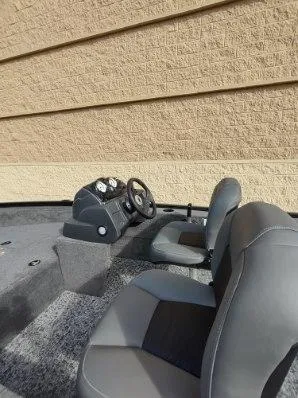 Slide: The Image of 2025 Tracker Super Guide V-16 SC boat interior with steering console and seats. - 6