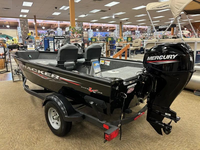 Slide: The Image of 2025 Tracker Super Guide V-16 SC boat with Mercury engine in showroom. - 2