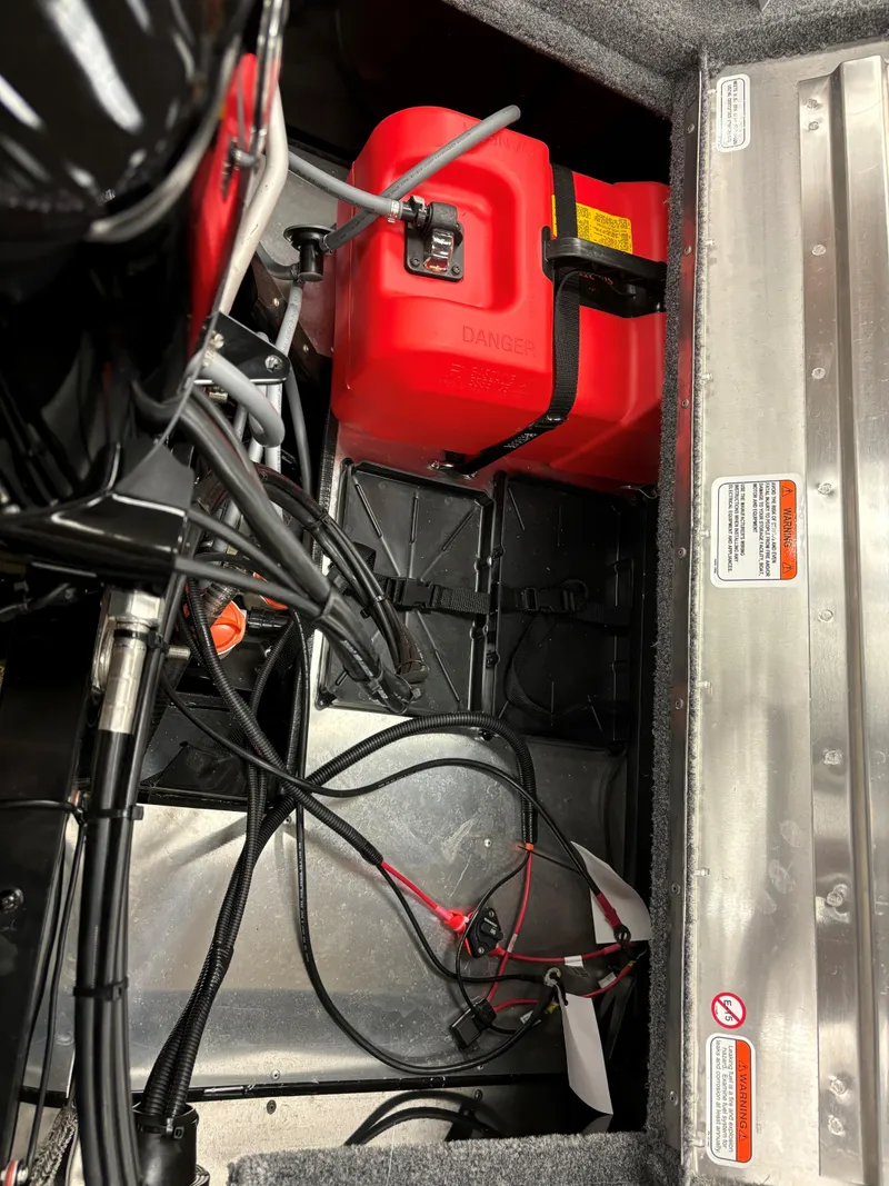 Slide: The Image of 2025 Tracker Super Guide V-16 SC boat interior with red fuel tank and wiring. - 9