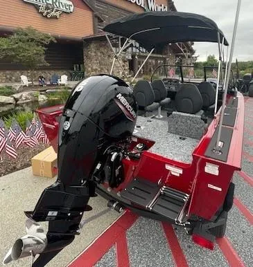 Slide: The Image of 2025 Tracker Targa V-18 Combo boat with Mercury engine, displayed outdoors. - 2