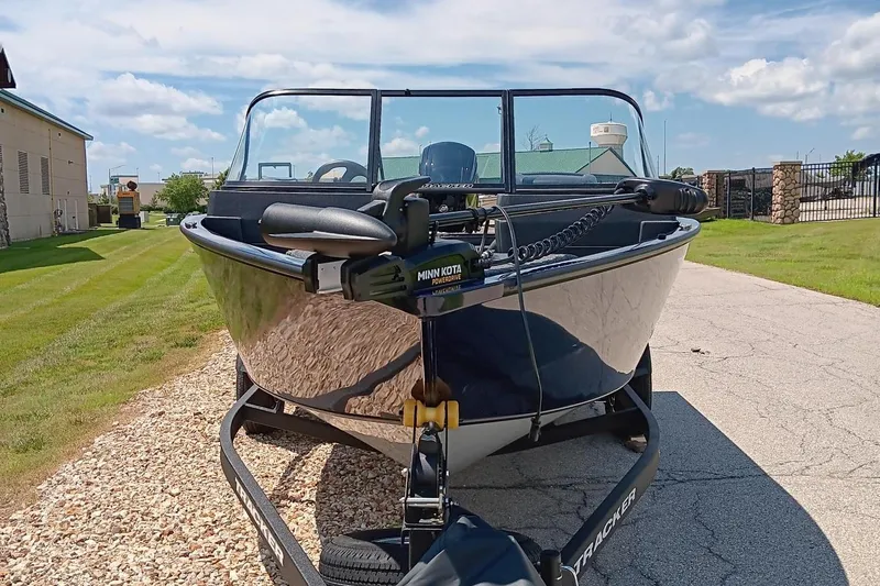 Slide: The Image of 2025 Tracker Pro Guide V-175 WT boat on trailer, parked outdoors. - 2