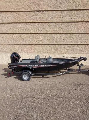 Slide: The Image of 2025 Tracker Super Guide V-16 SC fishing boat on trailer, parked outdoors. - 2