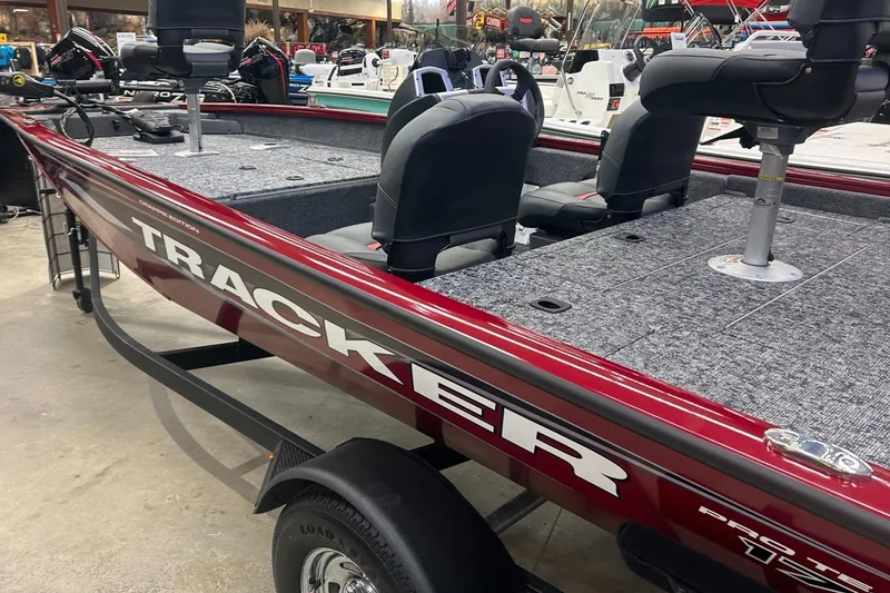 Slide: The Image of 2025 Tracker Pro Team 175 Crappie Edition boat interior with steering console and fishing rod holders. - 4