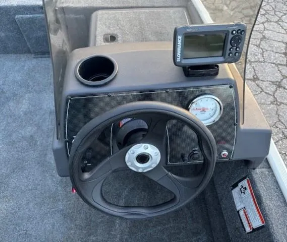 Slide: The Image of 2025 Tracker Bass Tracker Classic XL dashboard with steering wheel and fish finder. - 7