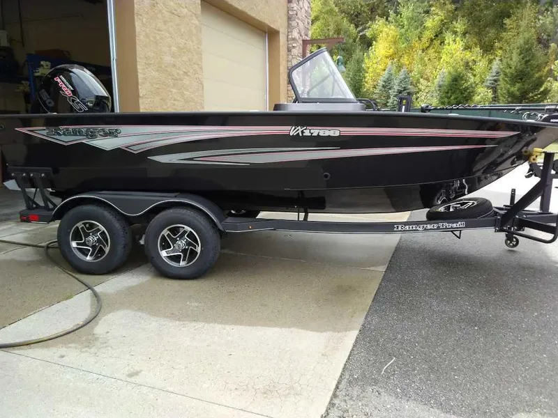 The Image of 2024 Ranger VX1788 WT boat on trailer, parked outside a garage. - 0