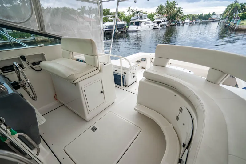 Slide: The Image of 1995 Tiara Yachts 4300 Open interior with seating, docked by a serene waterfront. - 16