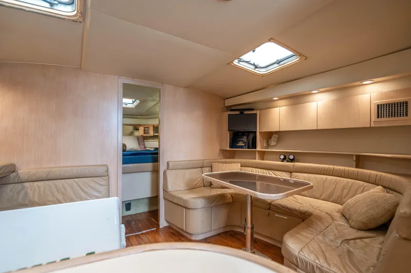 Slide: The Image of 1995 Tiara Yachts 4300 Open interior with beige seating and wooden accents. - 22
