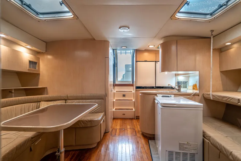 Slide: The Image of Interior of 1995 Tiara Yachts 4300 Open, featuring a cozy dining area and compact kitchen. - 23