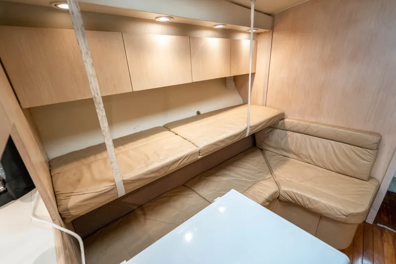 Slide: The Image of 1995 Tiara Yachts 4300 Open interior with beige seating and overhead storage. - 24