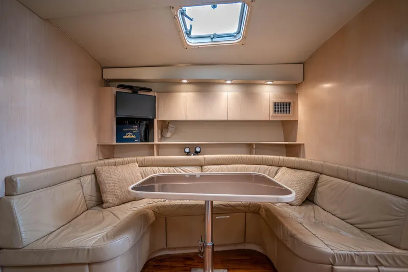 Slide: The Image of 1995 Tiara Yachts 4300 Open interior with beige leather seating and a skylight. - 25