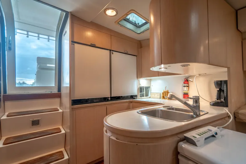 Slide: The Image of 1995 Tiara Yachts 4300 Open interior kitchen with modern amenities and wooden cabinetry. - 26