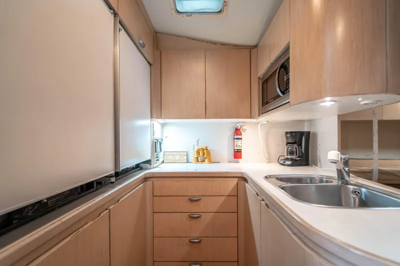 Slide: The Image of 1995 Tiara Yachts 4300 Open kitchen with modern appliances and wooden cabinetry. - 27